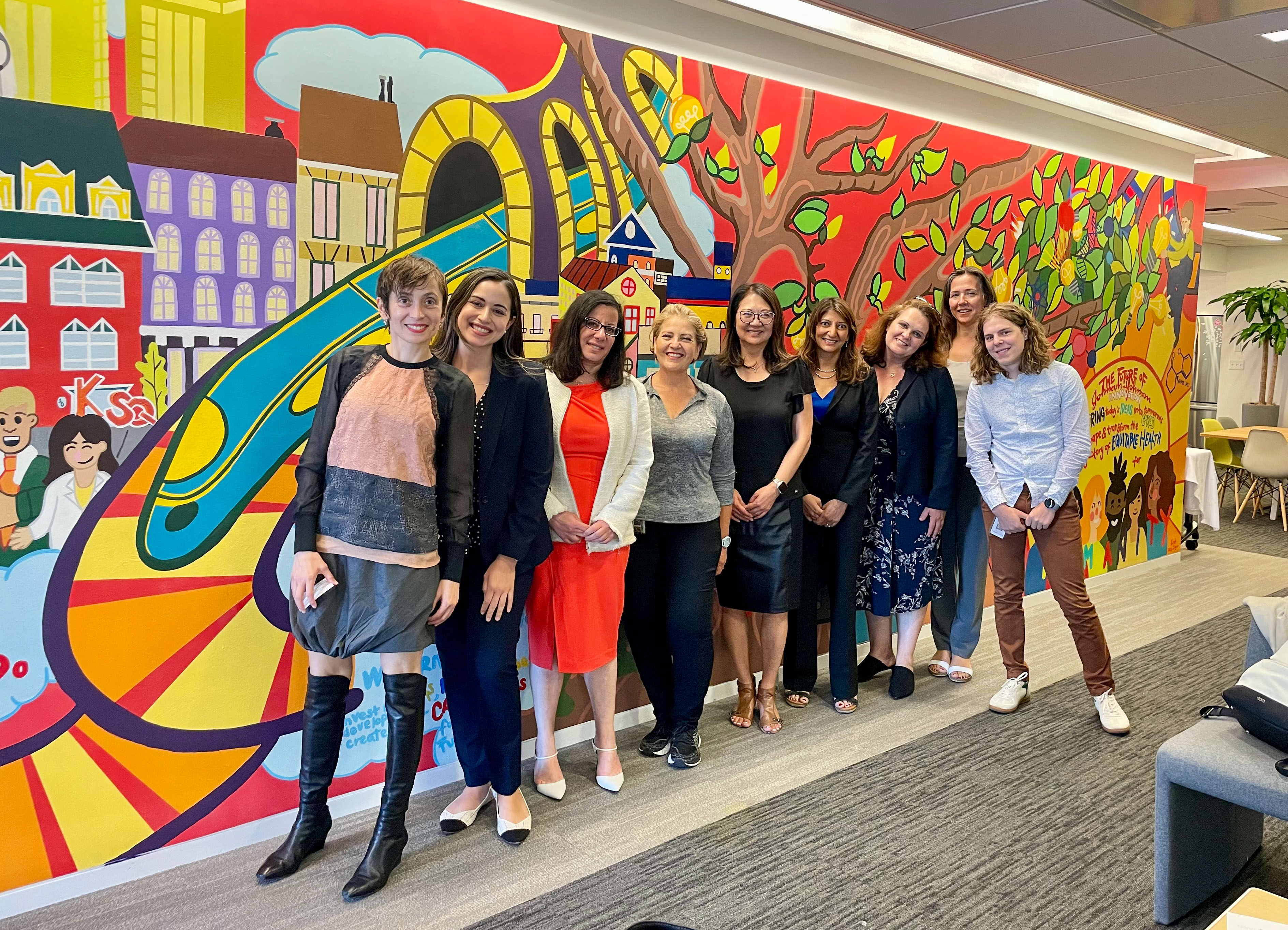 group portrait of female Northwestern faculty entrepreneurs and mentors before a colorful mural at a corporate visit in Boston